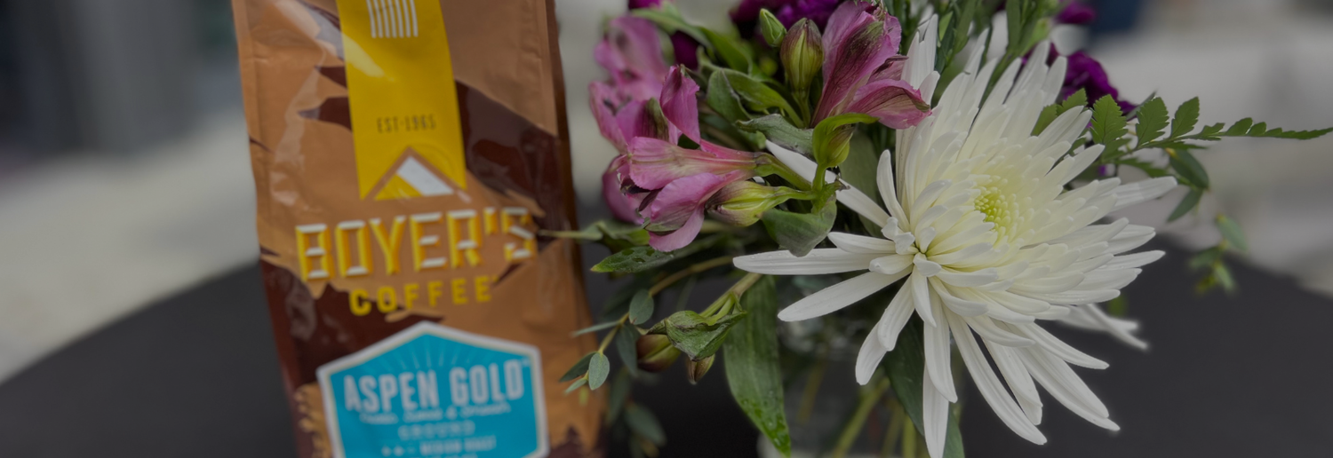 Box of Boyer's Coffee and a bouquet of flowers on a table.