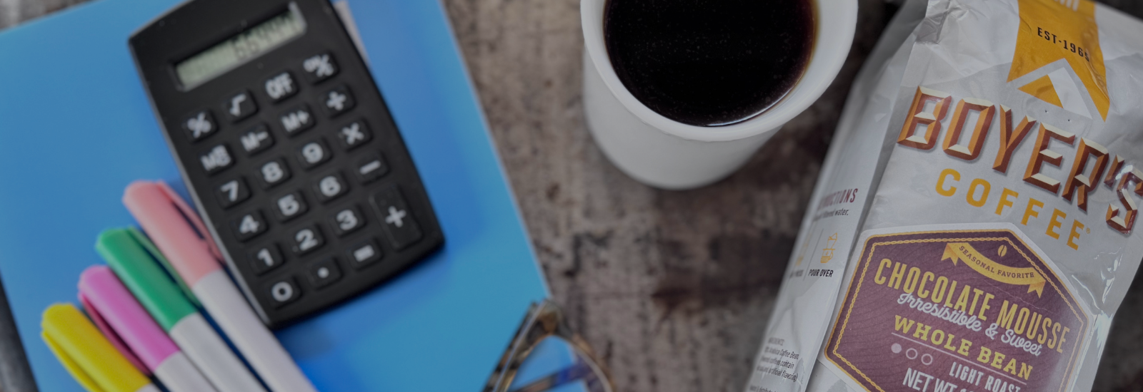 Calculator, coffee, and coffee package on a table