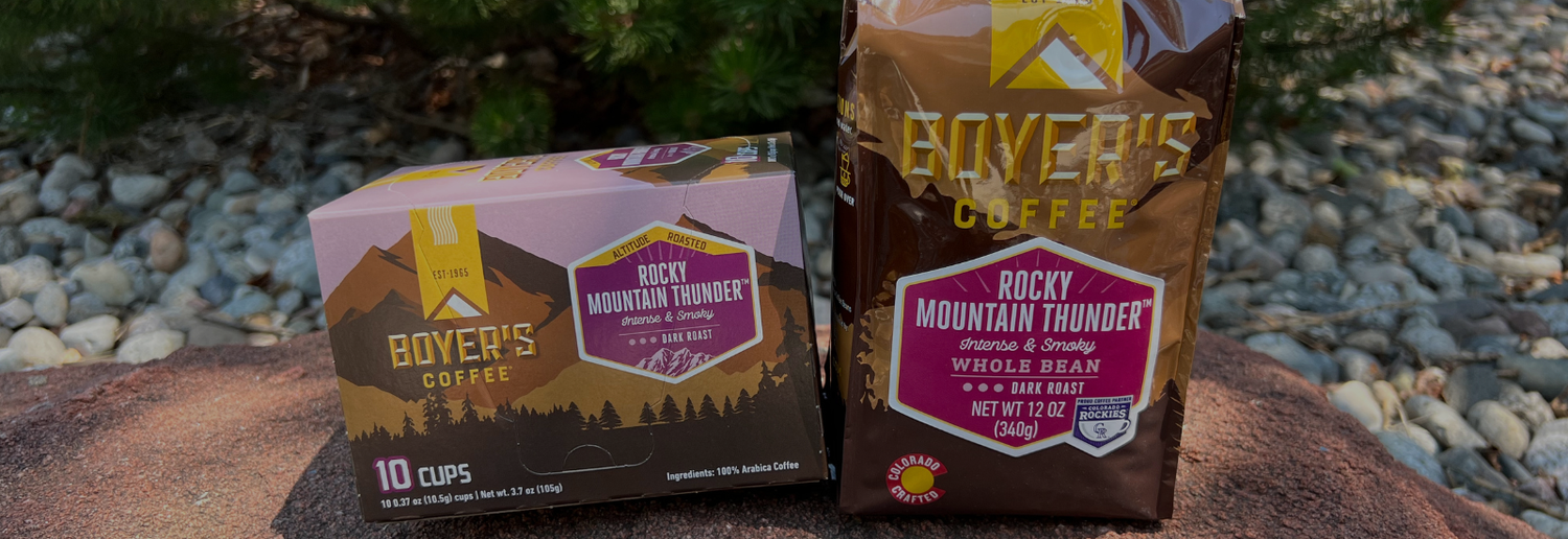 Two boxes of Boyer's Coffee Rocky Mountain Thunder on a stone surface with a natural background.