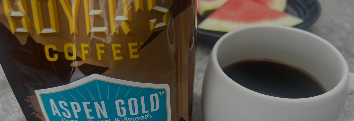 Aspen Gold coffee bag with a cup of coffee in the foreground