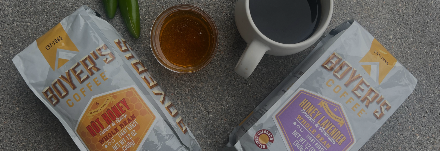 Boyer's Coffee packages with a cup of coffee and a jar on a textured surface