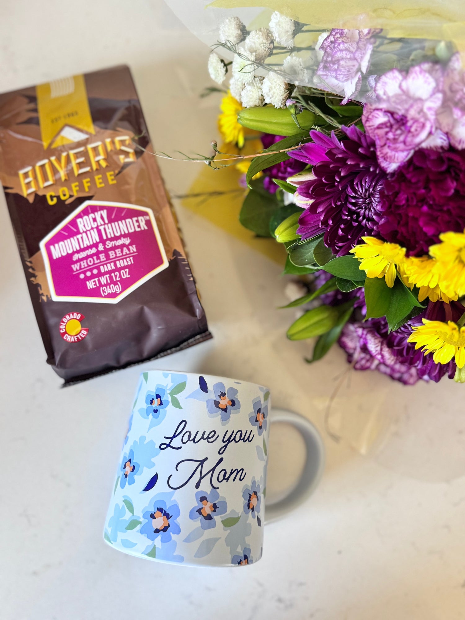 Bag of Rocky Mountain Thunder Boyer's Coffee with a floral bouquet and mug that says "love you mom"